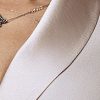 Close-up of silky satin shawl collar and gathered puff sleeve on custom beige dress