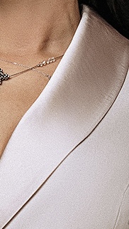 Close-up of silky satin shawl collar and gathered puff sleeve on custom beige dress